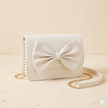 White handbag with a large bow on a beige background