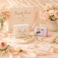 Two handbags, one with a bow and the other with a teddy bear design, on a decorative table with flowers and packaging.