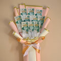 Bouquet made of banknotes with decorative ribbons on a white background