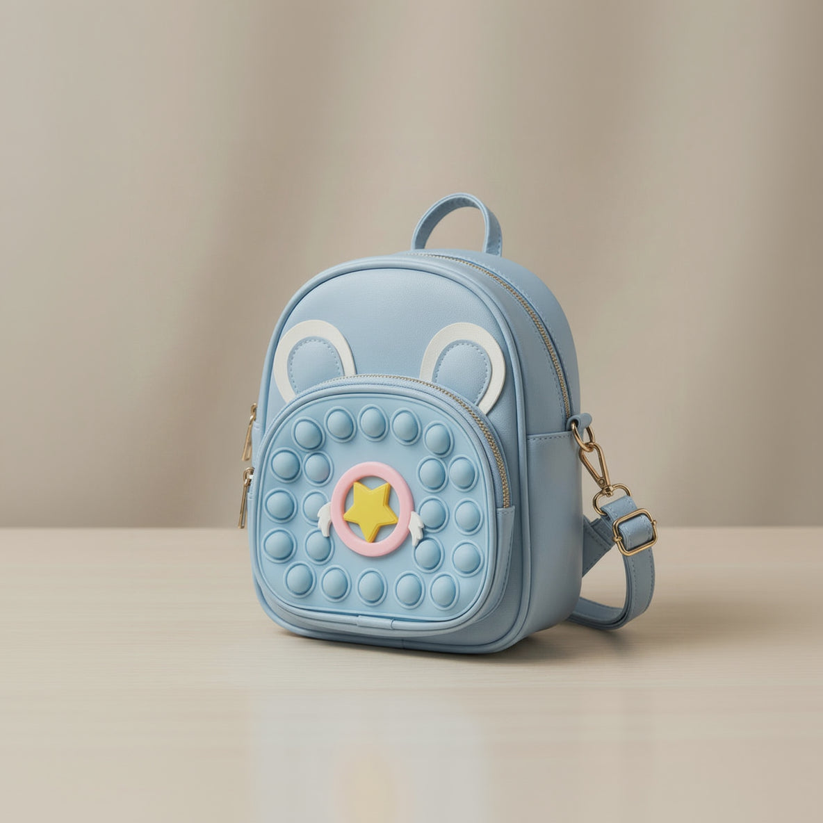 Light blue backpack with animal ears and a star design on a beige background